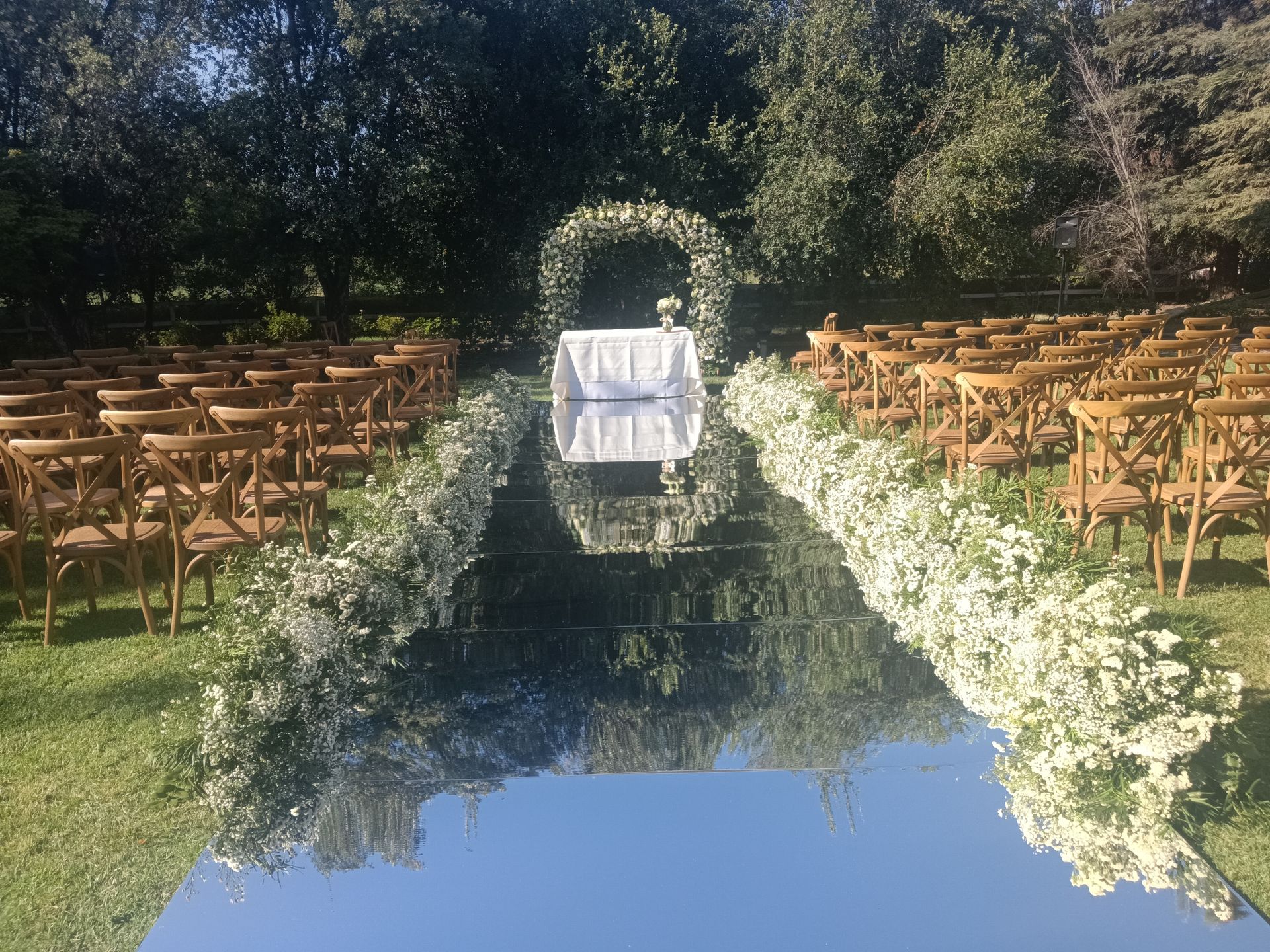 Hermoso altar simbólico arco curvo floreado total , piso de espejo y camino lineal floreado estilo nube. Florería Rosamor te ofrece bellos arcos florales para matrimonio en muchos…