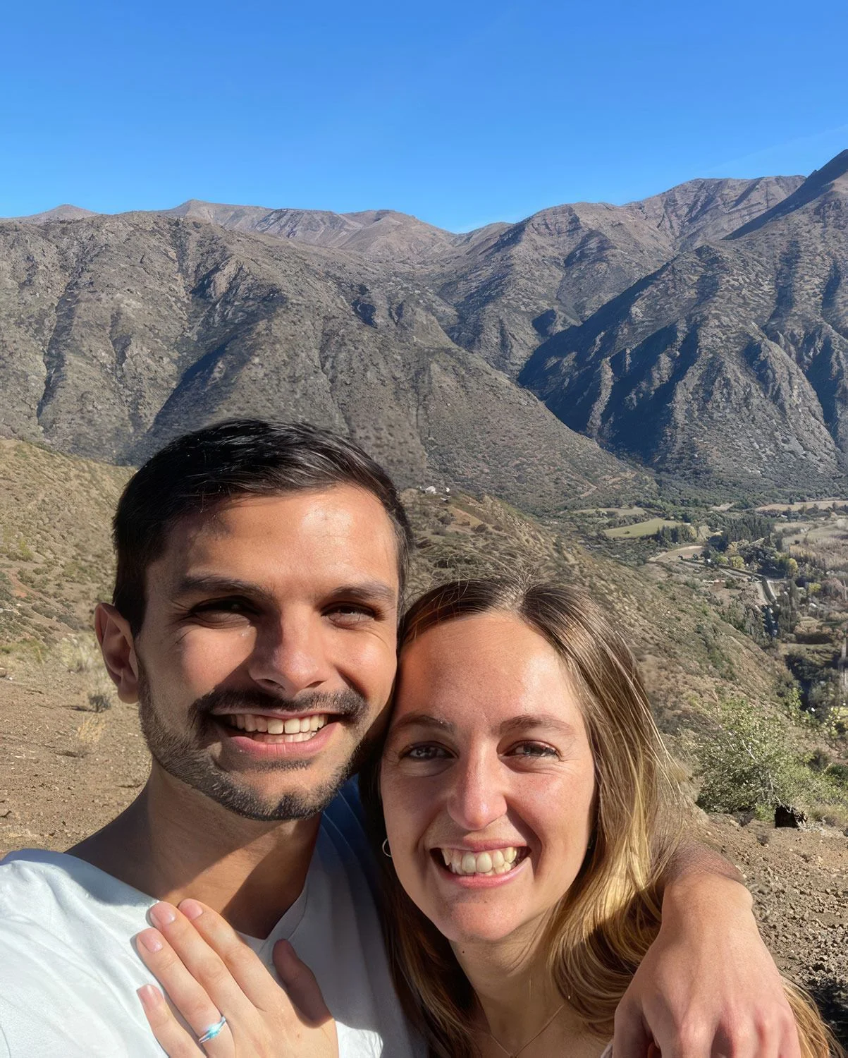 Pareja celebrando pedida de matrimonio con anillo de compromiso